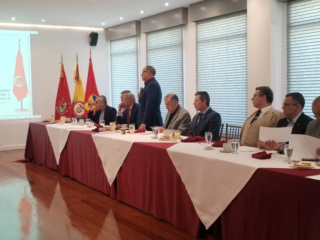 Mesa principal durante una sesión del Consejo, con las banderas institucionales
